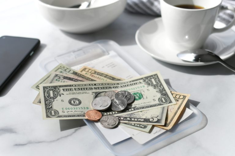 Paying for your bill tab at a restaurant cafe with cash money. Make sure you leave a tip!